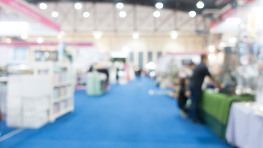 Stand espositivi a una fiera del turismo, progettati per attrarre visitatori e promuovere servizi, con layout accattivante e posizionamento strategico.