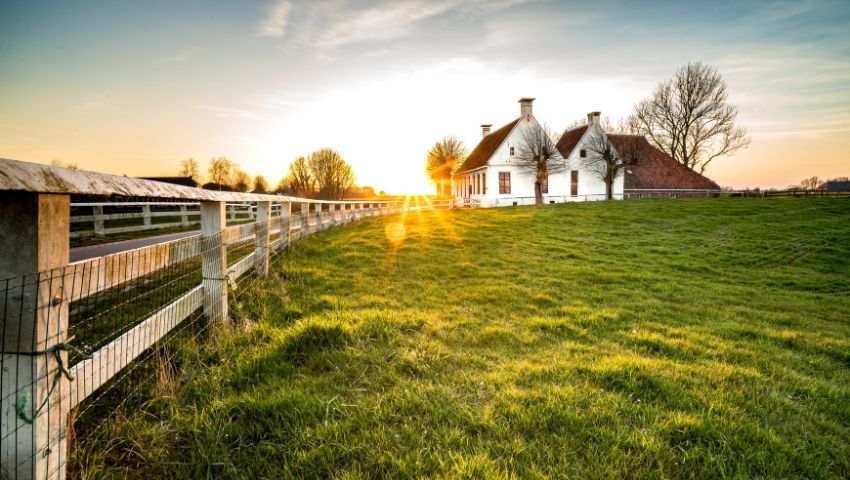 Tenuta agricola immersa nel verde al tramonto, esempio di agri-turismo sostenibile e autentico contatto con la campagna 4.0.